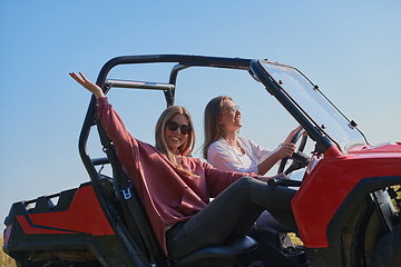 Image showing girls enjoying a beautiful sunny day while driving an off-road car