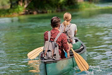 Image showing friends are canoeing in a wild river