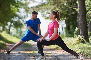 Image showing couple enjoying in a healthy lifestyle warming up and stretching before jogging