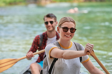 Image showing friends are canoeing in a wild river