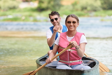 Image showing friends are canoeing in a wild river