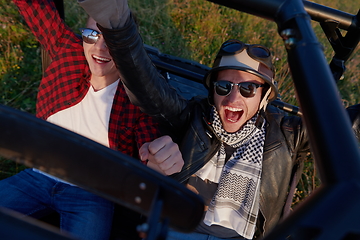 Image showing two young happy excited men enjoying beautiful sunny day while driving a off road buggy car