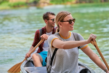 Image showing friends are canoeing in a wild river