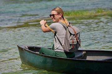 Image showing woman adventurous explorer are canoeing in a wild river