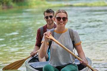 Image showing friends are canoeing in a wild river