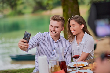 Image showing couple taking selfie while having picnic french dinner party outdoor