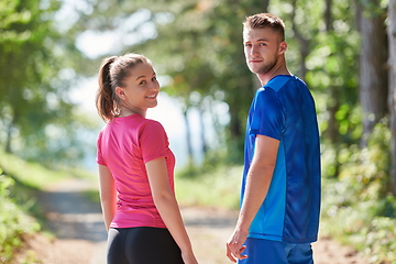 Image showing couple enjoying in a healthy lifestyle while jogging on a country road