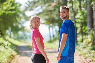 Image showing couple enjoying in a healthy lifestyle while jogging on a country road