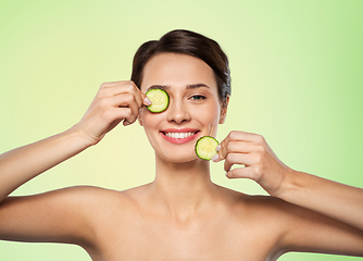 Image showing beautiful woman making eye mask of cucumbers