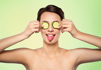 Image showing beautiful woman making eye mask of cucumbers