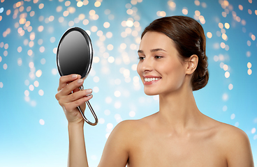 Image showing beautiful young woman looking to mirror