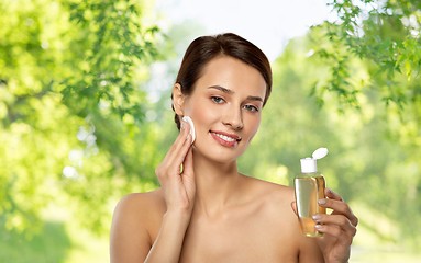 Image showing young woman with toner or cleanser and cotton pad