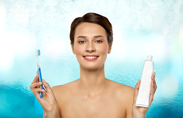 Image showing smiling woman with toothbrush cleaning teeth