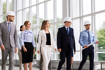 Image showing business team in helmets walking along office