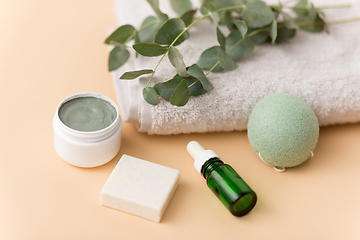 Image showing serum, clay mask, oil and eucalyptus on bath towel