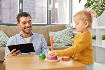 Image showing father with tablet pc and baby daughter at home