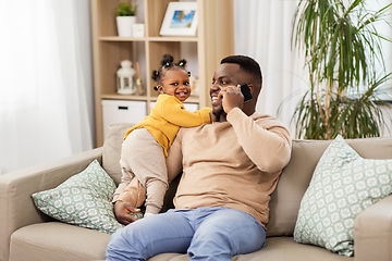 Image showing father with baby at home calling on smartphone