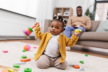 Image showing african baby girl playing with toy blocks at home