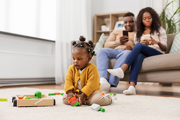 Image showing african baby girl playing with toy blocks at home