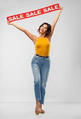 Image showing happy smiling young woman posing with sale banner