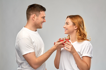 Image showing happy couple in white t-shirts with christmas gift