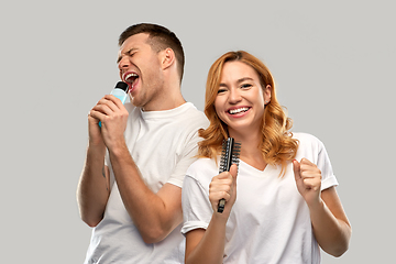 Image showing happy couple singing to hairbrush and lotion