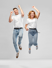 Image showing happy couple in white t-shirts jumping