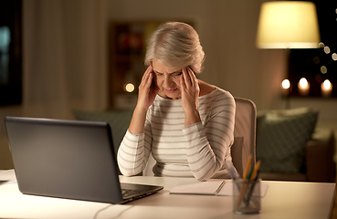 Image showing tired senior woman with laptop at home at night