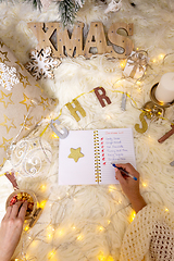 Image showing Writing out a Christmas list under the tree