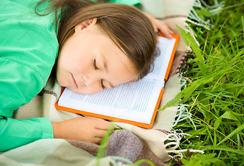 Image showing Girl is sleeping on her book outdoors