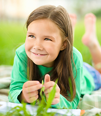 Image showing Portrait of a little girl laying on green grass