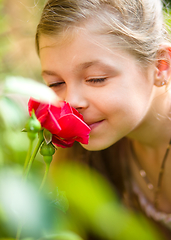 Image showing Portrait of a cute little girl smelling rose