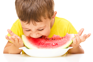 Image showing Little boy is eating watermelon