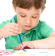 Image showing Little boy is playing with paints