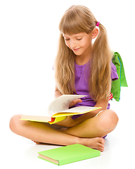 Image showing Little girl is reading a book