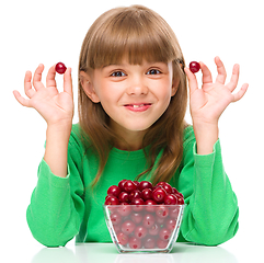 Image showing Cute girl is eating cherries