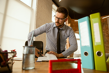 Image showing A young businessman moving in office, getting new work place