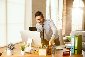 Image showing A young businessman moving in office, getting new work place