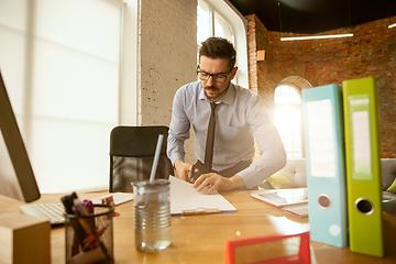 Image showing A young businessman moving in office, getting new work place