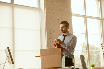 Image showing A young businessman moving in office, getting new work place