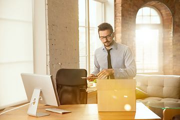 Image showing A young businessman moving in office, getting new work place