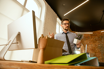 Image showing A young businessman moving in office, getting new work place