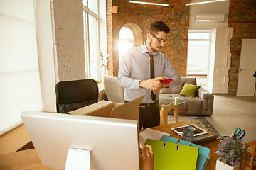 Image showing A young businessman moving in office, getting new work place