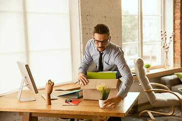 Image showing A young businessman moving in office, getting new work place