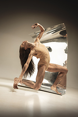 Image showing Young and stylish modern ballet dancer on brown background