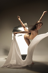 Image showing Young and stylish modern ballet dancer on brown background