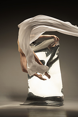 Image showing Young and stylish modern ballet dancer on brown background