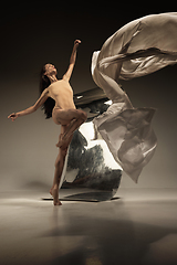 Image showing Young and stylish modern ballet dancer on brown background