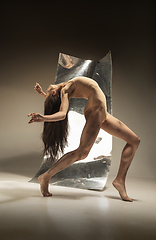 Image showing Young and stylish modern ballet dancer on brown background