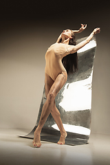 Image showing Young and stylish modern ballet dancer on brown background